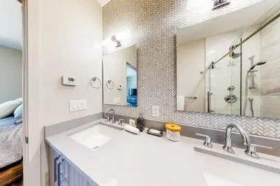 a bathroom with a sink and a large mirror at Woodhaven Hideaway in Frisco