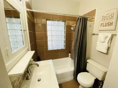 a bathroom with a toilet and a sink and a shower at Stunning Bungalow next to UNC - Free Bikes! in Greeley