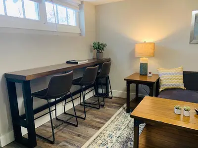 a bar in a living room with chairs and a couch at Inviting Bungalow Next to UNC - Free Cruiser Bikes in Greeley