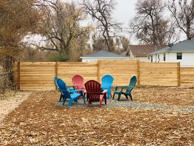 a group of colorful chairs in front of a fence at Inviting Bungalow Next to UNC - Free Cruiser Bikes in Greeley