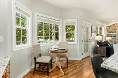 a dining room with a table and chairs and windows at Fabulous Family-Friendly Retreat by Windsor Lake! in Windsor