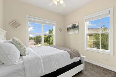 a white bedroom with a bed and two windows at Fabulous Family-Friendly Retreat by Windsor Lake! in Windsor