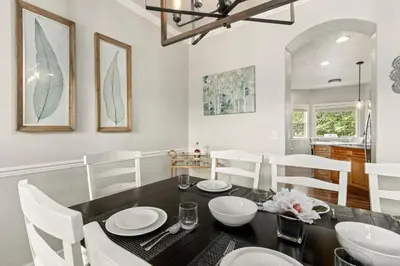 a dining room with a black table and white chairs at Fabulous Family-Friendly Retreat by Windsor Lake! in Windsor