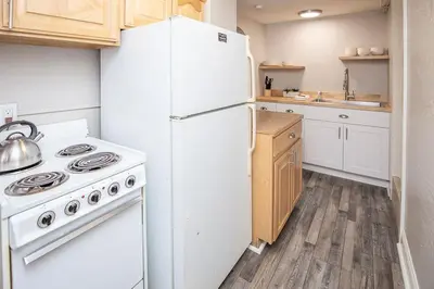 a kitchen with a white refrigerator and a stove at Cozy Retreat - Walk to UNC - Free Cruiser Bikes in Greeley