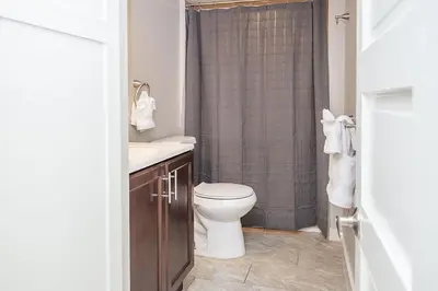 a bathroom with a toilet and a sink and a shower at Cozy Retreat - Walk to UNC - Free Cruiser Bikes in Greeley