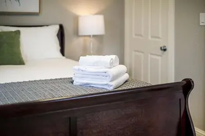 a pile of towels sitting on a table next to a bed at Couples Getaway - Walk to UNC - Free Cruiser Bikes in Greeley