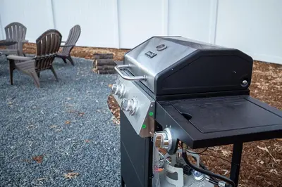 a bbq grill with two chairs and a table at Couples Getaway - Walk to UNC - Free Cruiser Bikes in Greeley