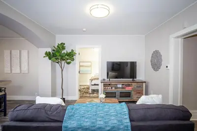 a living room with a couch and a tv at Couples Getaway - Walk to UNC - Free Cruiser Bikes in Greeley
