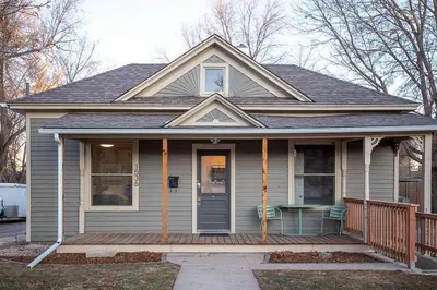 a house with a porch with a table on it at Couples Getaway - Walk to UNC - Free Cruiser Bikes in Greeley