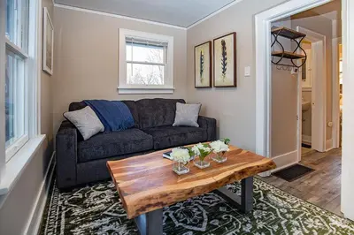 a living room with a couch and a wooden table at Cozy Carriage House - Walk to UNC + Free Bikes in Greeley