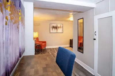 a living room with a blue chair and a table at Cozy Carriage House - Walk to UNC + Free Bikes in Greeley
