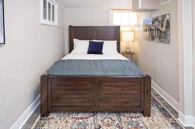 a bedroom with a bed with a wooden bed frame at Cozy Carriage House - Walk to UNC + Free Bikes in Greeley