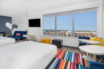 a bedroom with a bed and a large window at Aloft Denver North Westminster in Westminster