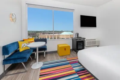 a bedroom with a bed and a table and a window at Aloft Denver North Westminster in Westminster
