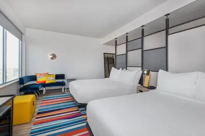a hotel room with two beds and a desk at Aloft Denver North Westminster in Westminster