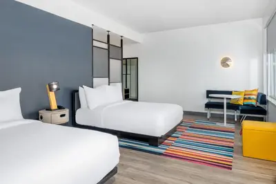 a hotel room with two beds and a desk at Aloft Denver North Westminster in Westminster