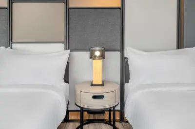 a bed room with two twin beds and a table with a lamp at Aloft Denver North Westminster in Westminster