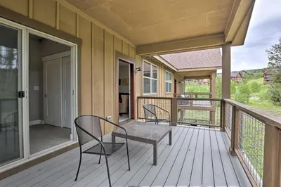 a porch with two chairs and a table on a deck at Fraser Retreat, Walk to Ski Shuttle and Main St in Fraser