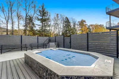 a hot tub on a deck with a fence at River West 811 in Silverthorne