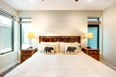 a bedroom with a bed with two lamps and windows at River West 811 in Silverthorne