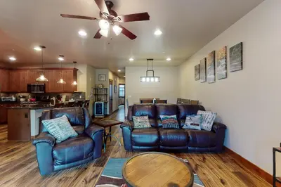 a living room with leather furniture and a ceiling fan at Riverfront Retreat in Silverthorne