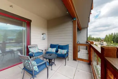 a patio with chairs and a table on a balcony at Riverfront Retreat in Silverthorne