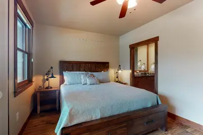 a bedroom with a bed with a wooden headboard and a window at Riverfront Retreat in Silverthorne