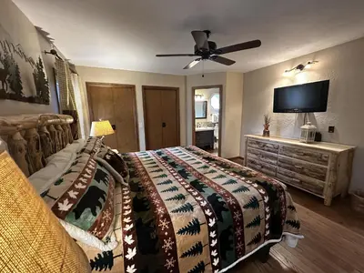 a bedroom with a bed and a flat screen tv at Heavenly Pines -- EV #3361 home in Estes Park