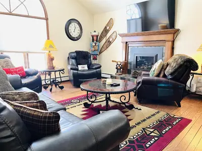 a living room with leather furniture and a fireplace at Heavenly Pines -- EV #3361 home in Estes Park