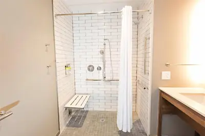 a bathroom with a shower with a bench in it at Staybridge Suites - Denver North - Thornton by IHG in Thornton