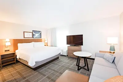 a hotel room with a bed and a couch at Staybridge Suites - Denver North - Thornton by IHG in Thornton