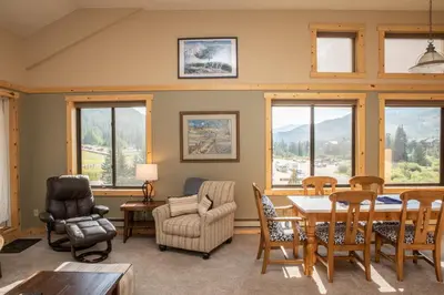 a living room with a table and chairs and windows at 2800 Slopeside condo in Keystone