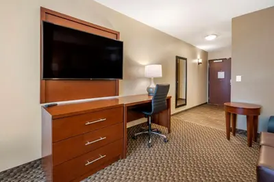 a hotel room with a desk with a flat screen tv at Comfort Suites Broomfield-Boulder-Interlocken in Broomfield