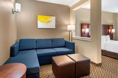 a living room with a blue couch in a hotel room at Comfort Suites Broomfield-Boulder-Interlocken in Broomfield
