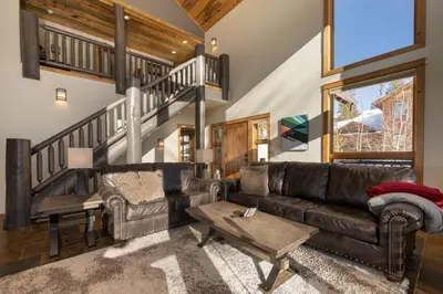 a living room with a leather couch and a table at Dreamcatcher at Lakota home in Winter Park