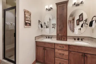 a bathroom with two sinks and two mirrors at Dreamcatcher at Lakota home in Winter Park