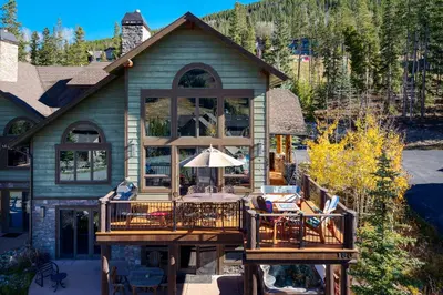 a house with a deck with a table and an umbrella at Dreamcatcher at Lakota home in Winter Park