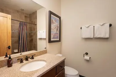 a bathroom with a sink and a toilet and a mirror at Dreamcatcher at Lakota home in Winter Park