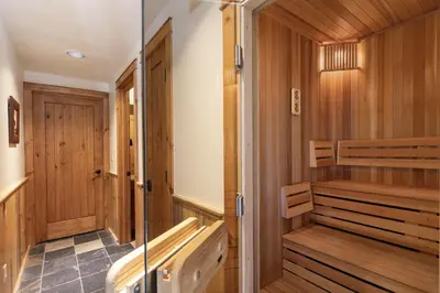 a sauna with wooden walls and a glass door at Dreamcatcher at Lakota home in Winter Park