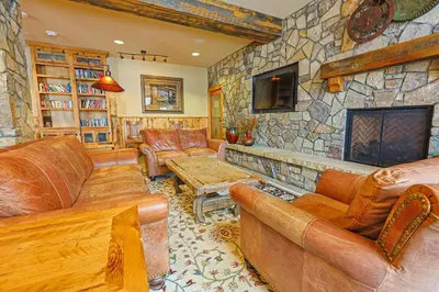 a living room with leather furniture and a stone wall at Black Bear 2 Bed 2 Bath BBCS in Dillon
