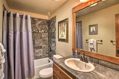 a bathroom with a sink and a toilet and a mirror at Fraser Condo with Views and Hot Tub Near Winter Park! in Fraser
