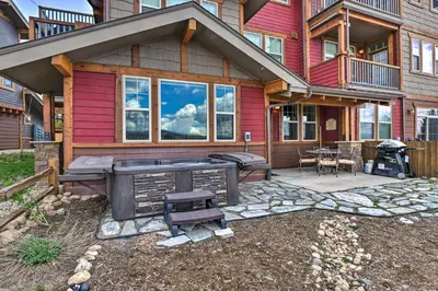 a large house with a grill and a patio at Fraser Condo with Views and Hot Tub Near Winter Park! in Fraser