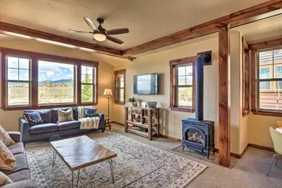 a living room with a couch and a stove at Fraser Condo with Views and Hot Tub Near Winter Park! in Fraser