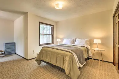 a bedroom with a large bed and a window at 2 Mi to Grand Lake Cabin with Fireplace and Library! in Grand Lake