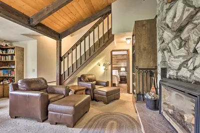 a living room with leather chairs and a fireplace at 2 Mi to Grand Lake Cabin with Fireplace and Library! in Grand Lake