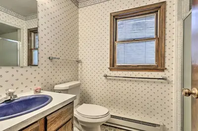a bathroom with a toilet and a sink and a window at 2 Mi to Grand Lake Cabin with Fireplace and Library! in Grand Lake