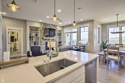 a kitchen with a sink and a living room at Winter Park Condo with Fireplace - 4 Mi to Slopes! in Winter Park