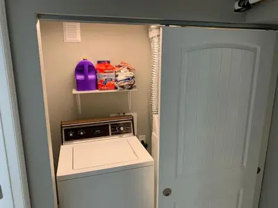 a small kitchen with a washing machine and a door at DIA HideAway -2BR, 15 min from DIA DT, Anschutz MD in Commerce City