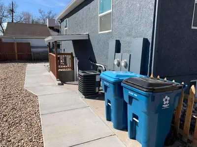 three blue trash cans sitting outside of a house at DIA HideAway -2BR, 15 min from DIA DT, Anschutz MD in Commerce City