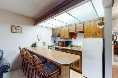 a kitchen with a wooden table and a refrigerator at Hi Country Haus 11-2 in Winter Park